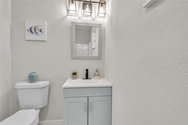 bathroom with toilet and vanity with extensive cabinet space