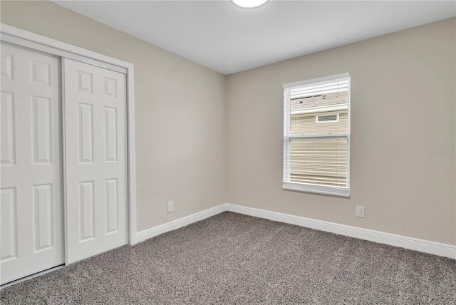 unfurnished bedroom featuring a closet and dark carpet