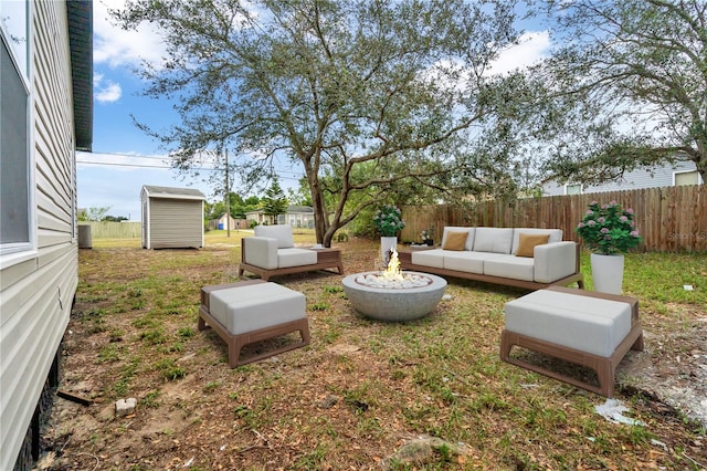 view of yard with an outdoor living space with a fire pit and a shed