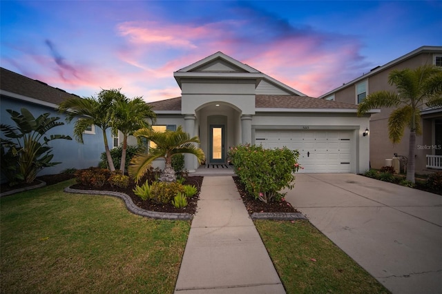 view of front of property featuring a garage and a yard