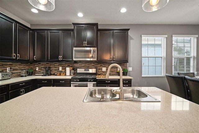 kitchen with decorative backsplash, sink, and appliances with stainless steel finishes