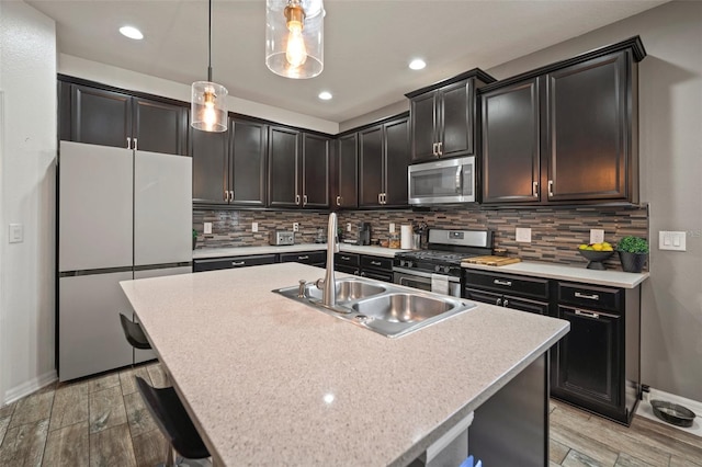 kitchen with backsplash, pendant lighting, an island with sink, and stainless steel appliances