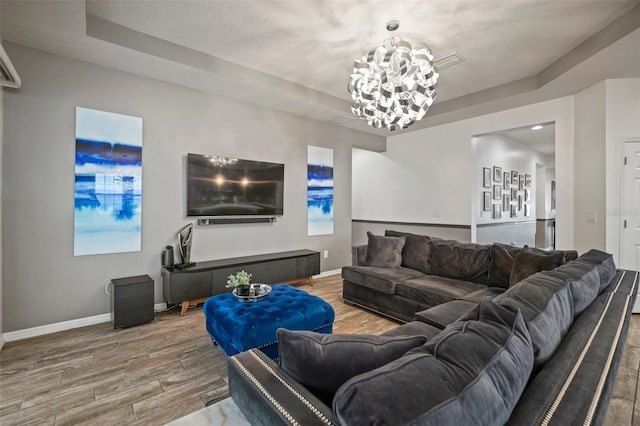 living room featuring a notable chandelier and a raised ceiling