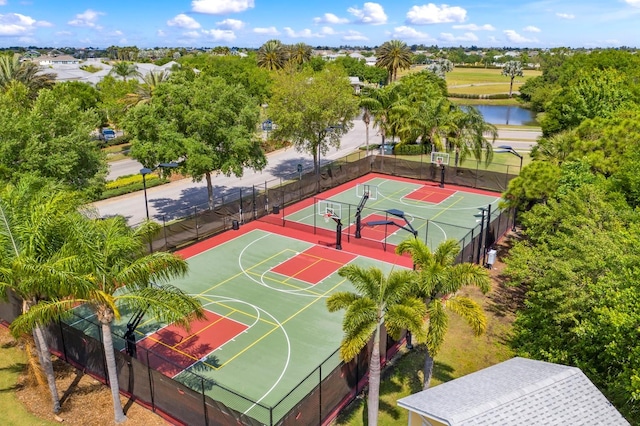 view of basketball court with tennis court and a water view