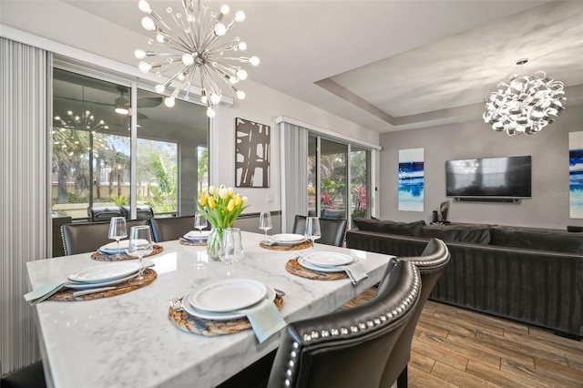 dining area featuring a raised ceiling and a chandelier