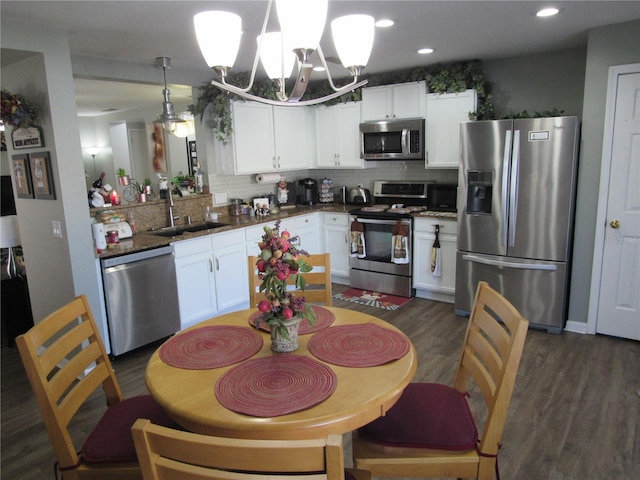 kitchen featuring sink, white cabinetry, decorative light fixtures, dark hardwood / wood-style floors, and stainless steel appliances