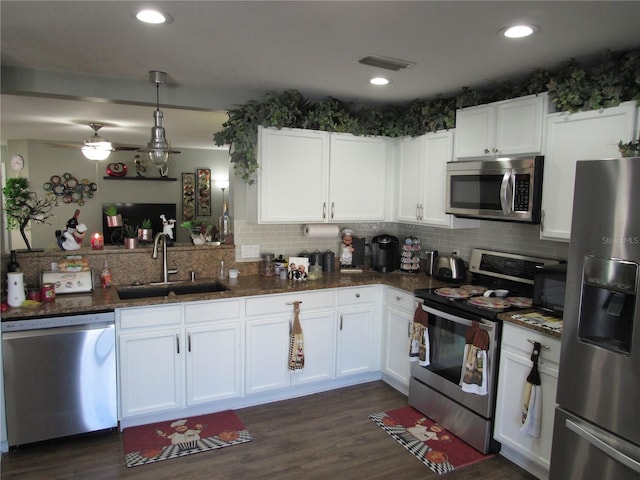 kitchen featuring pendant lighting, stainless steel appliances, sink, and white cabinets