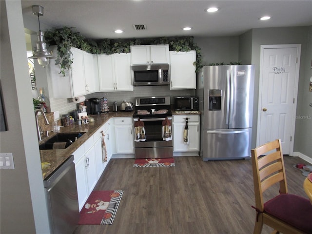 kitchen featuring sink, white cabinets, hanging light fixtures, stainless steel appliances, and dark wood-type flooring