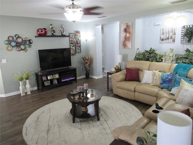 living room featuring ceiling fan and dark hardwood / wood-style floors