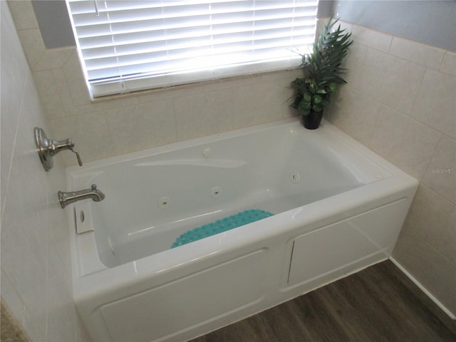 bathroom featuring a tub to relax in and hardwood / wood-style floors