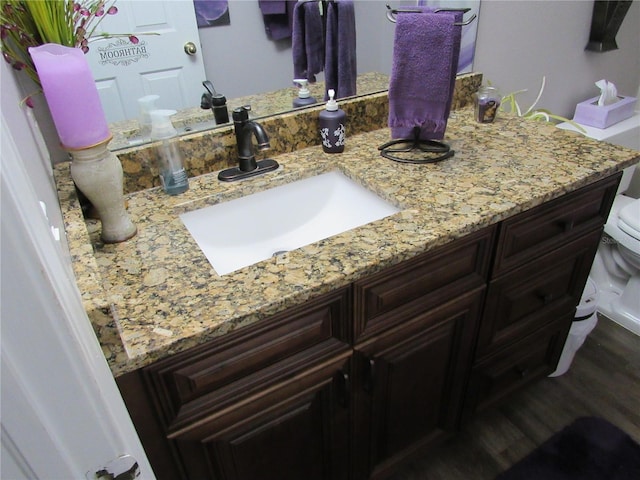 bathroom featuring hardwood / wood-style flooring, vanity, and toilet