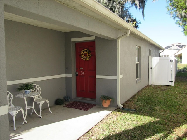 entrance to property featuring a lawn