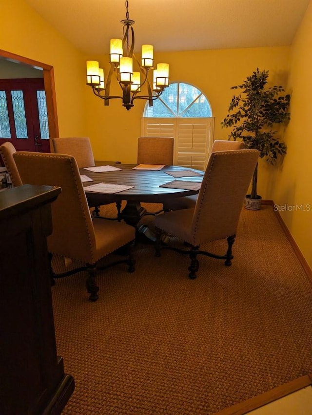 carpeted dining area featuring a notable chandelier