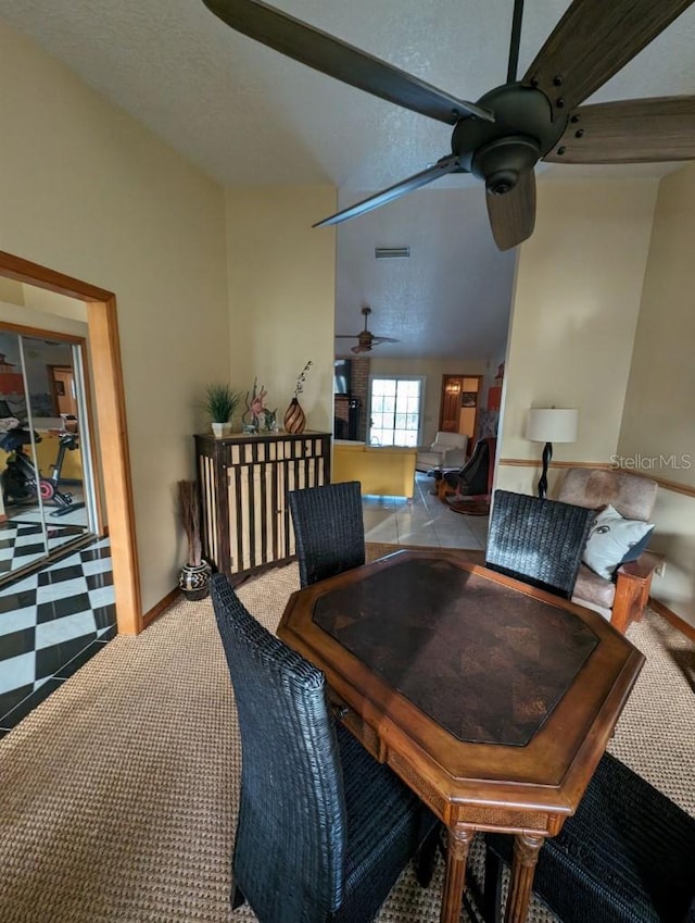 dining room with ceiling fan, light tile floors, and lofted ceiling