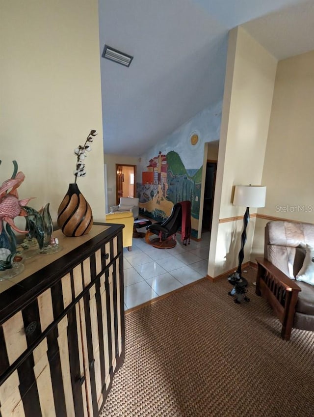 hall featuring light tile floors and vaulted ceiling