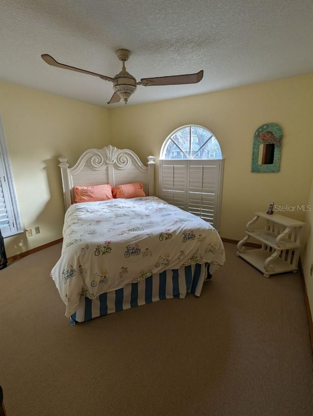 carpeted bedroom featuring a textured ceiling and ceiling fan