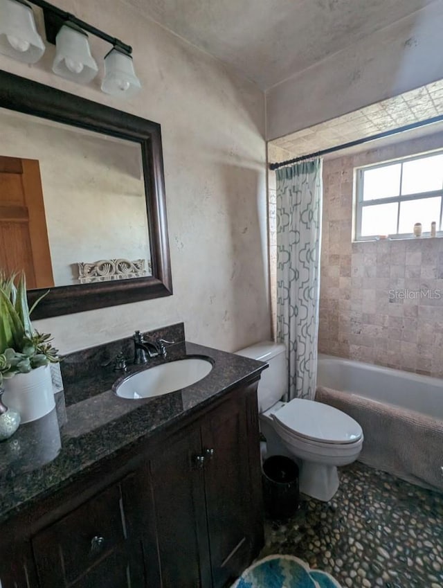 full bathroom with vanity, shower / bath combo with shower curtain, and toilet