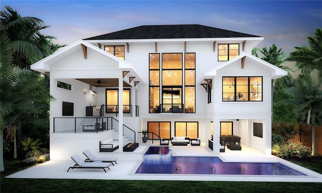 back house at dusk with outdoor lounge area, a patio area, ceiling fan, and a yard