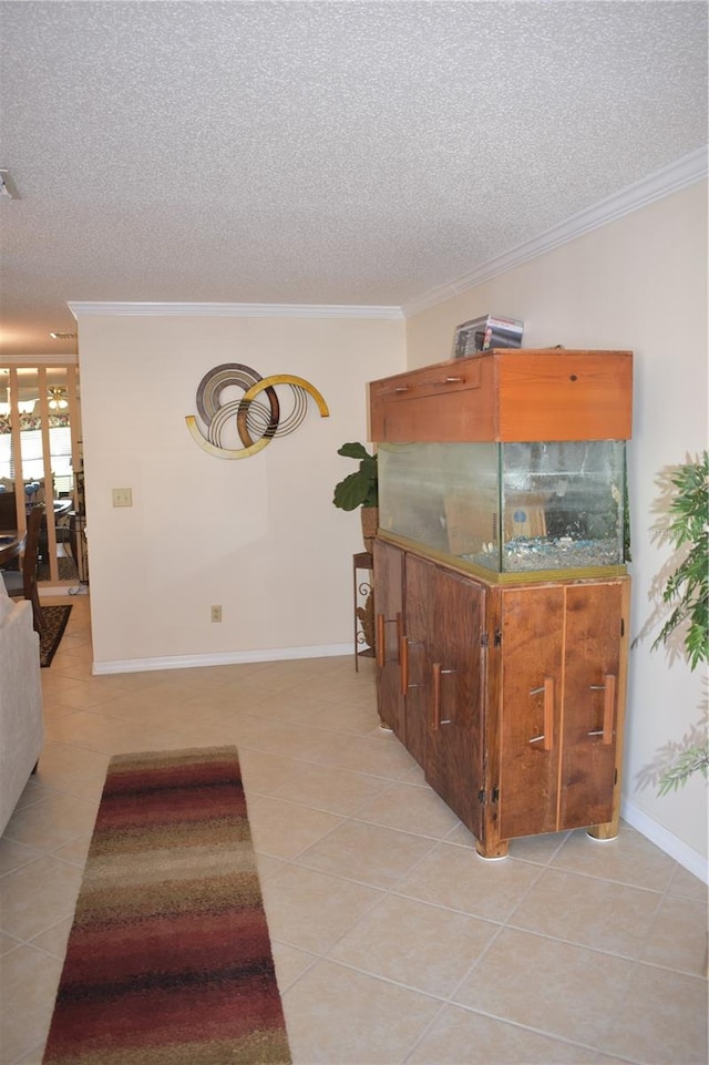 interior space with a textured ceiling, crown molding, and light tile flooring