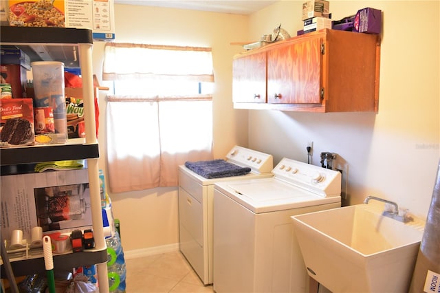 washroom featuring washing machine and clothes dryer, cabinets, light tile flooring, and sink