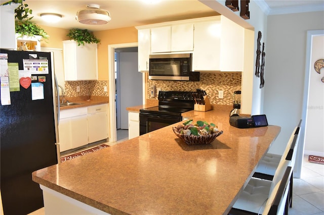 kitchen with a kitchen breakfast bar, backsplash, black appliances, and light tile flooring