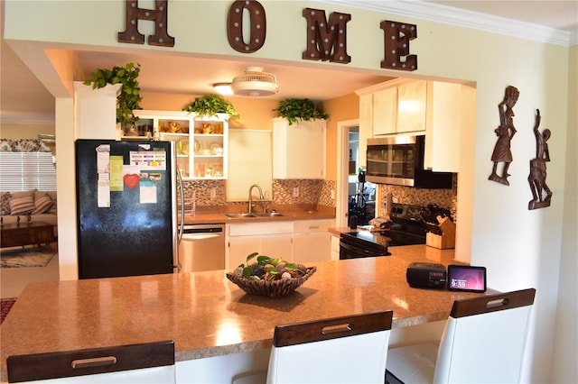 kitchen featuring backsplash, black appliances, sink, white cabinets, and ornamental molding