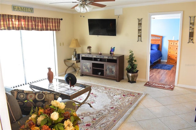 living room featuring light tile floors, plenty of natural light, ceiling fan, and ornamental molding