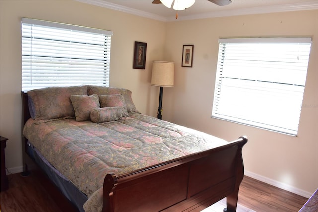 bedroom with hardwood / wood-style floors, ornamental molding, ceiling fan, and multiple windows