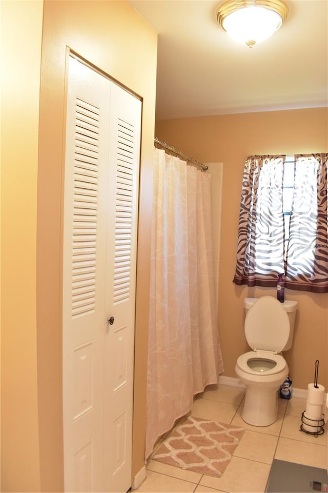 bathroom featuring tile floors and toilet