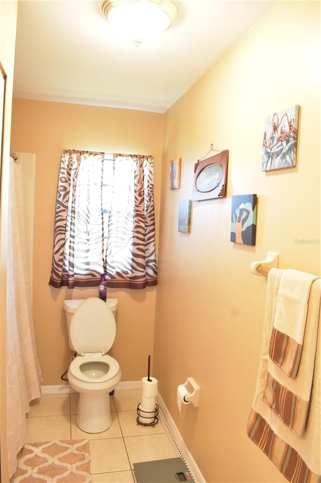 bathroom featuring toilet and tile floors