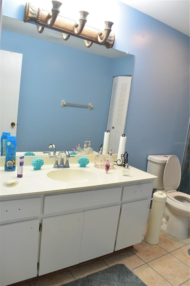 bathroom featuring toilet, tile floors, and vanity with extensive cabinet space