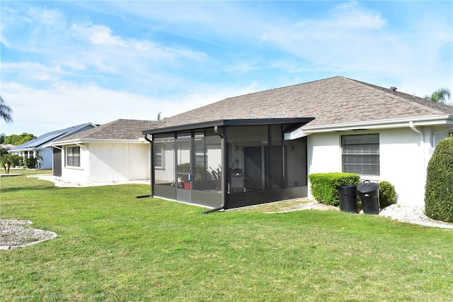 back of house featuring solar panels, a sunroom, and a yard