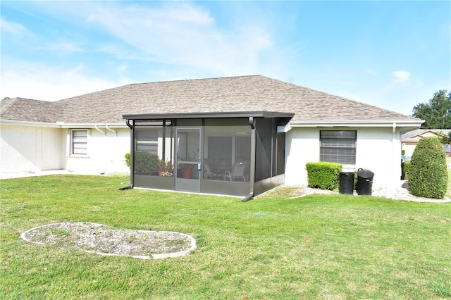 rear view of house with a yard and a sunroom