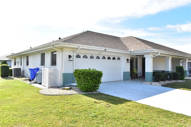 single story home featuring a front lawn, a garage, and central air condition unit