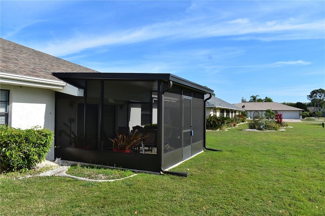 view of side of property with a yard and a sunroom