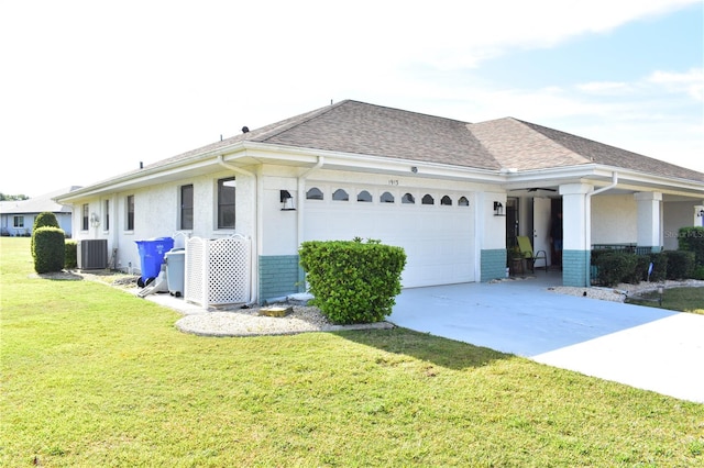 view of front of home with a front lawn, central AC, and a garage