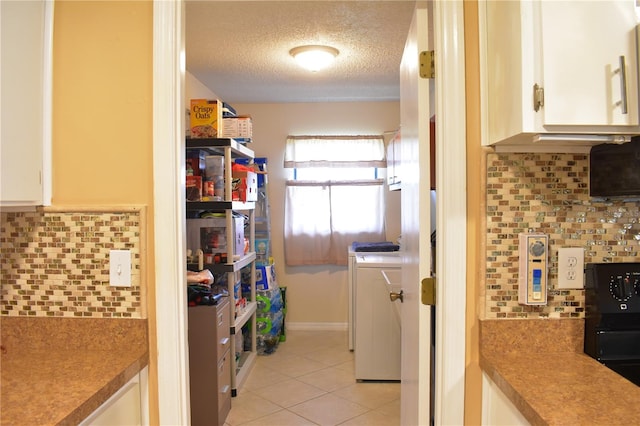 kitchen featuring white cabinetry, a textured ceiling, tasteful backsplash, and light tile flooring