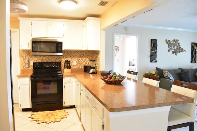 kitchen featuring black range with electric cooktop, light tile flooring, tasteful backsplash, and a breakfast bar