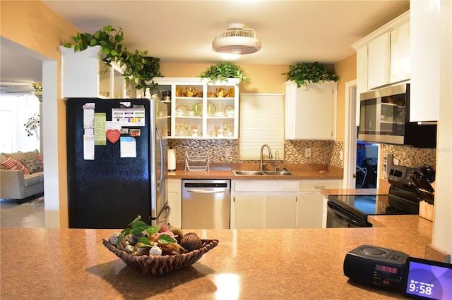 kitchen with white cabinetry, backsplash, ceiling fan, appliances with stainless steel finishes, and sink