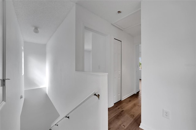 hall with hardwood / wood-style flooring and a textured ceiling