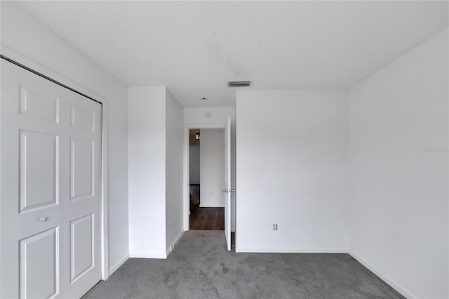 unfurnished bedroom with a closet, a textured ceiling, and carpet flooring