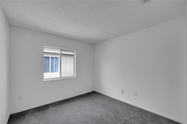 carpeted empty room with a textured ceiling