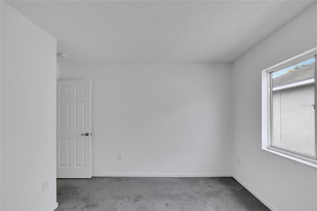 spare room featuring a textured ceiling and carpet floors