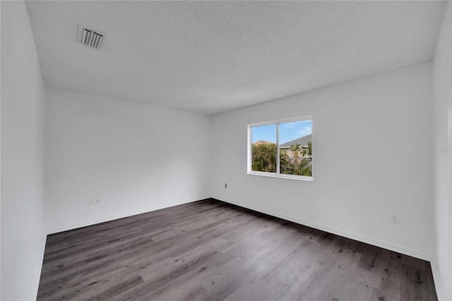 unfurnished room featuring a textured ceiling and hardwood / wood-style flooring