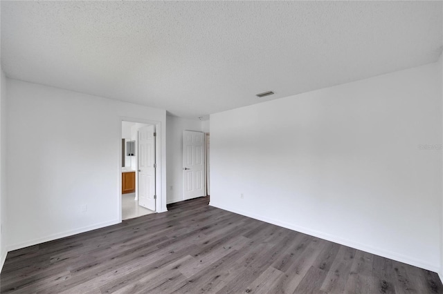 unfurnished room with hardwood / wood-style flooring and a textured ceiling