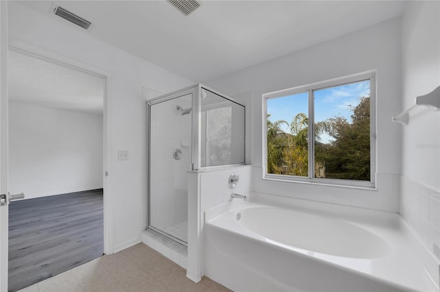 bathroom with independent shower and bath and hardwood / wood-style floors