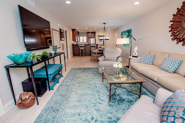 living room featuring a chandelier and light hardwood / wood-style flooring