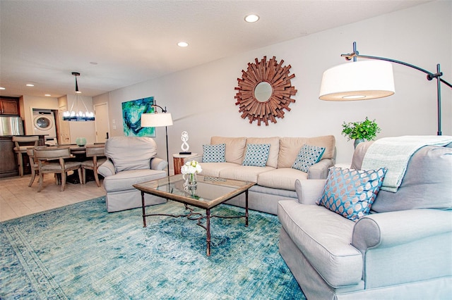 living room featuring an inviting chandelier and stacked washer and dryer