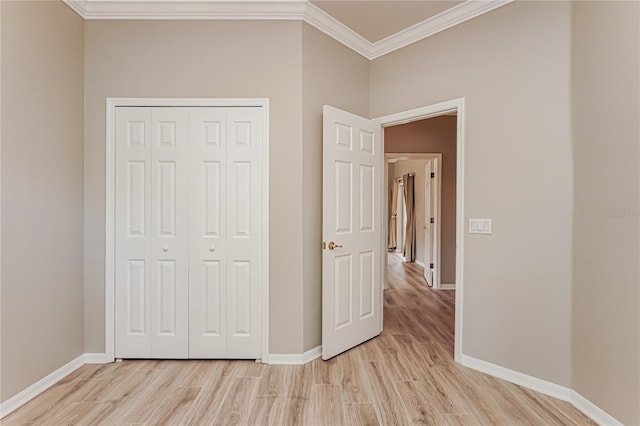 unfurnished bedroom with light hardwood / wood-style floors, a closet, and ornamental molding