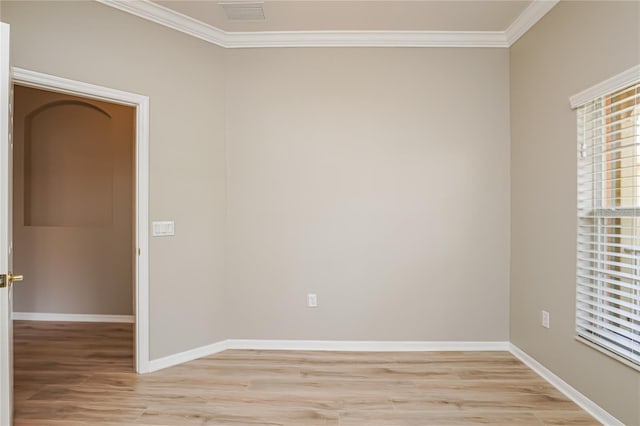 empty room featuring crown molding and light wood-type flooring